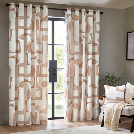 Carro Abstract Lined Eyelet Curtains in Clay, cream cotton panels with clay-toned geometric shapes on black eyelet rings, shown framing a glass door in a living room.