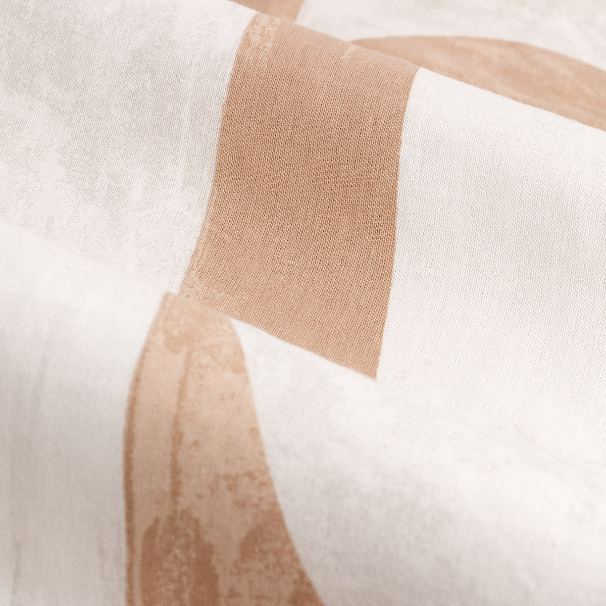 Close-up of Carro lined eyelet curtain fabric in clay, showing an abstract geometric print with mottled clay-toned blocks and curves on cream cotton weave.