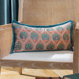 Casa Velvet Cotton Cushion in dusky rose with embroidered teal frond pattern and French blue border, shown on a cane-back chair.
