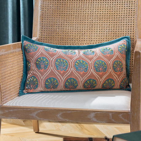 Casa Velvet Cotton Cushion in dusky rose with embroidered teal frond pattern and French blue border, shown on a cane-back chair.