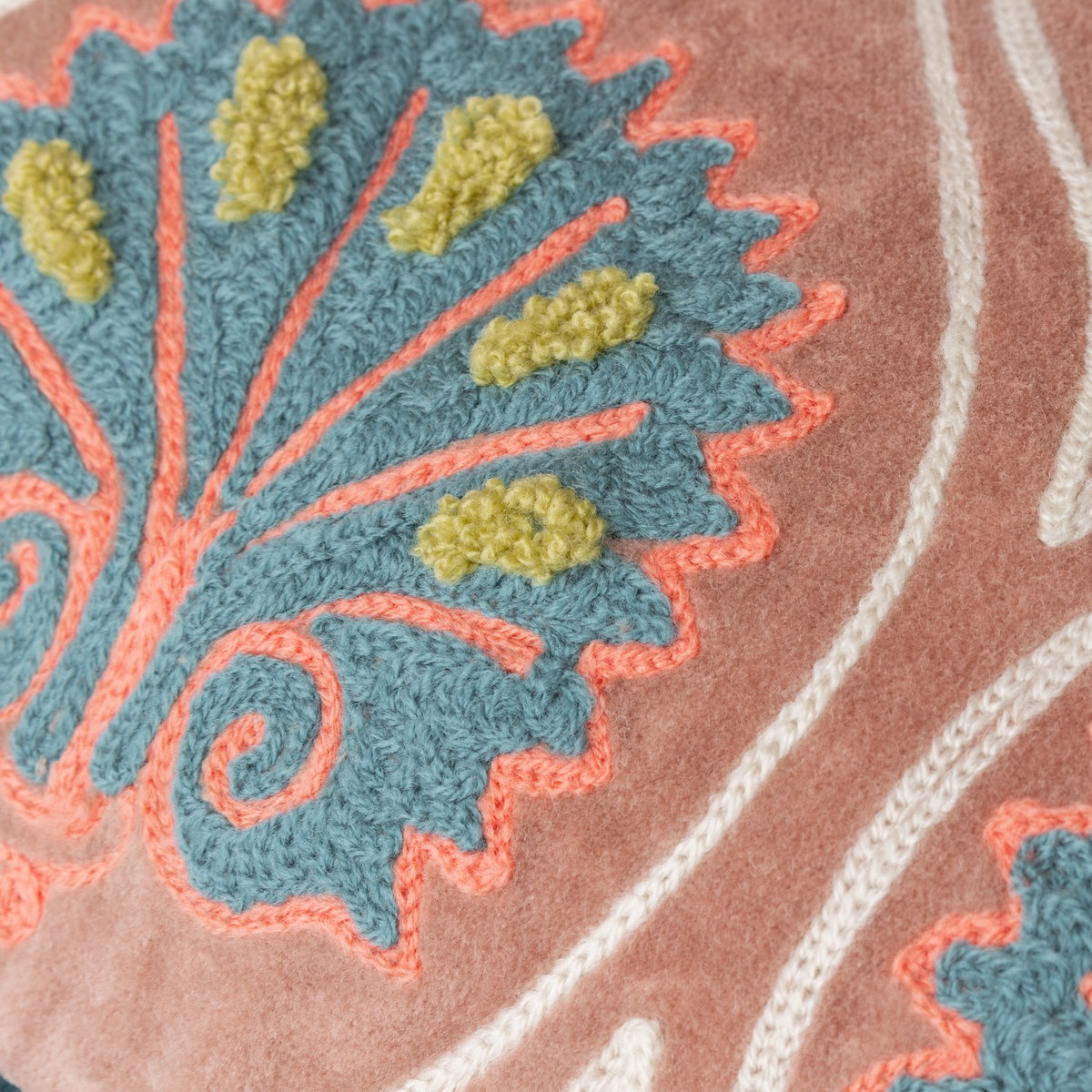 Close-up of the Casa Velvet Cotton Cushion in rose, showing embroidered teal frond pattern with coral outlines and raised chartreuse yarn tufts on velvet.