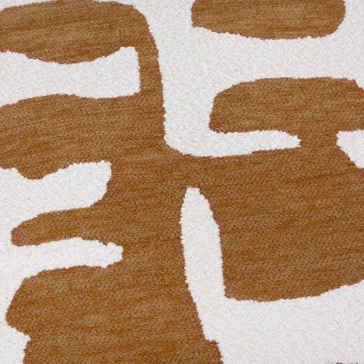 Close-up of the Caval Velvet Chenille Cushion in bronze, showing an abstract jacquard pattern of bronze organic shapes woven onto a cream chenille and boucle textured ground.