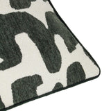 Close-up corner detail of the Caval Velvet Chenille Cushion in Ivy Green, showing a bold abstract pattern in dark green chenille pile against an off-white ground, with green piped edge trim.