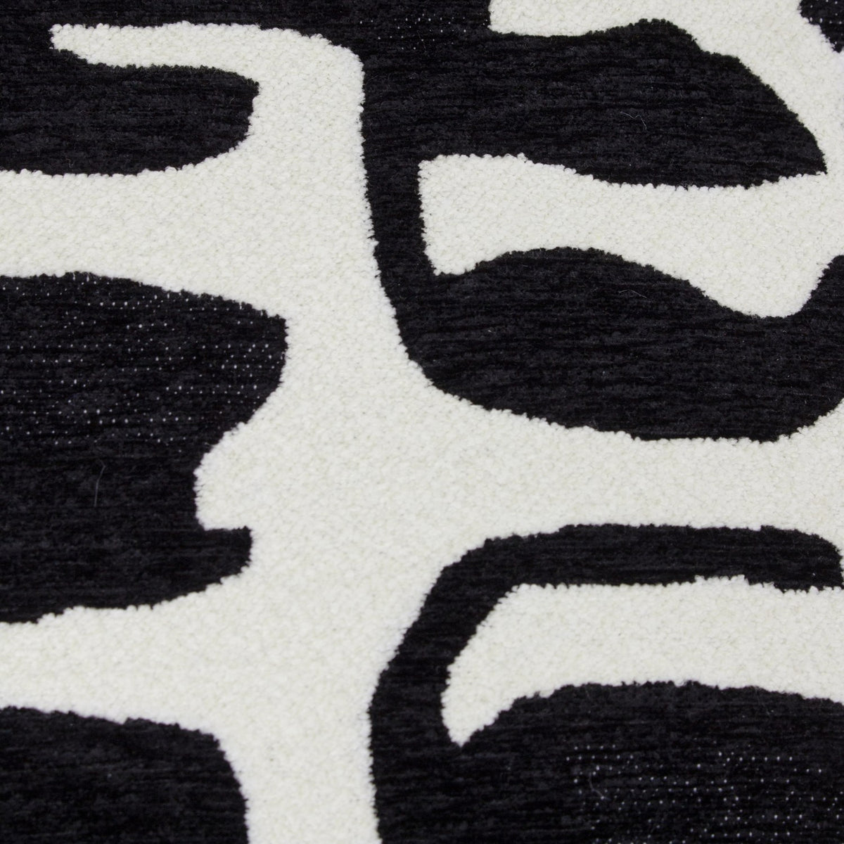 Close-up of the Caval Velvet Chenille Cushion in Mono, showing an abstract black jacquard pattern with textured boucle and smooth chenille on an off-white ground.