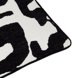 Close-up corner of the Caval Velvet Chenille Cushion in Mono, showing black abstract jacquard shapes on an off-white ground with a black piped edge.