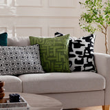 Caval Velvet Chenille Cushion in Mono, a black and white abstract square cushion on a beige sofa, styled with green patterned and geometric print cushions.