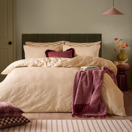 Club Checkerboard Plain Check Duvet Cover Set in latte with waffle-textured squares, styled on a bed with checked pillowcases and a burgundy throw in a bedroom setting.