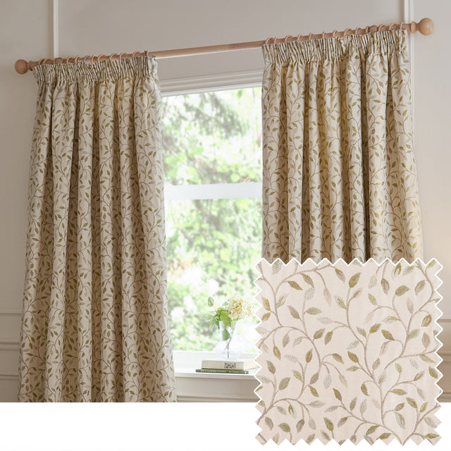 Cervino pencil pleat curtains in Lichen, jacquard leaf design in green and taupe on cream fabric, shown pleated on a wooden pole beside a window, with a fabric swatch inset.