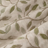 Cervino pencil pleat curtain fabric close-up in cream polyester with jacquard trailing leaf design in muted green and taupe tones, showing textured woven detail.