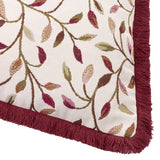 Close-up of the Cervino jacquard cotton blend cushion in Damson, showing a woven leaf and vine pattern in wine, pink and green on cream, edged with damson fringe trim.