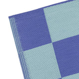 Close-up of the Checkerboard Jacquard Check Rug in blue, showing woven polypropylene texture with alternating periwinkle and duck-egg blue squares and a folded edge, on a white background.