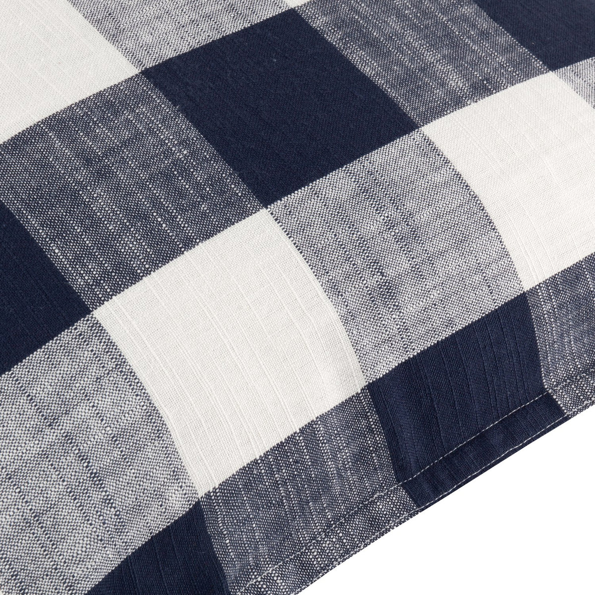 Close-up of the Chesil Check Printed Cotton Cushion in navy, showing a large buffalo check pattern in navy and cream cotton fabric with a stitched edge.