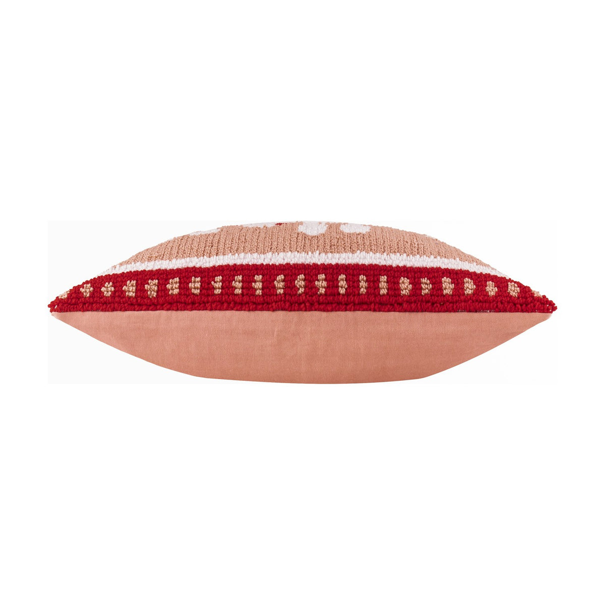 Side view of the Candy Ho Ho Ho cushion showing its plump edge, blush pink cotton reverse, and tufted red-and-white patterned border, on a plain white background.