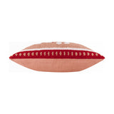 Side view of the Candy Ho Ho Ho cushion showing its plump edge, blush pink cotton reverse, and tufted red-and-white patterned border, on a plain white background.
