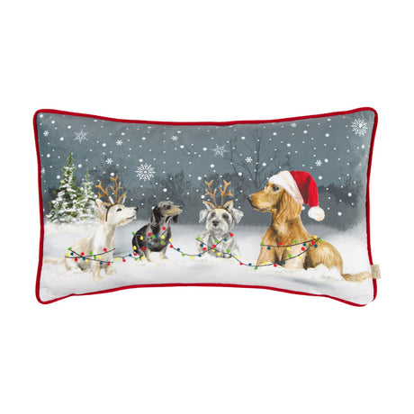 Rectangular velvet cushion with red piping, printed with four dogs in snow wearing a Santa hat and reindeer antlers tangled in Christmas lights, on a plain white background.