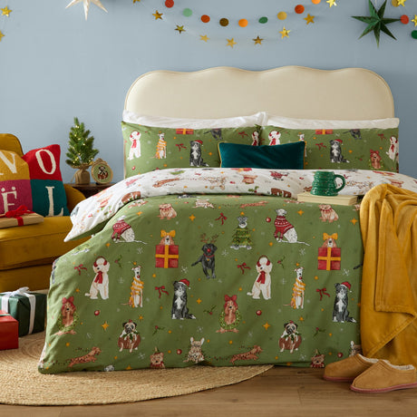 Christmas Pawty Cotton Reversible Duvet Cover Set in green, styled on a bed with festive dog, present and star prints, cream headboard, and holiday accessories in a bedroom setting.