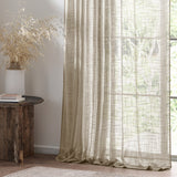 Cirrus Plain Linen Curtain Panel in beige, sheer woven polyester with a textured weave, shown hanging by a window in a living room setting.
