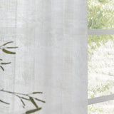 Cirrus Plain Polyester Curtain Panel in snow white, sheer woven fabric with subtle texture, hung beside a window with a leafy outdoor view.