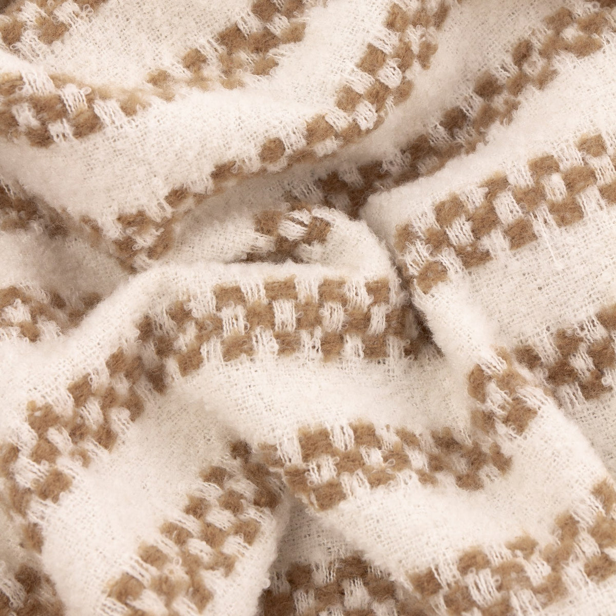 Close-up of the Clyne Check Polyester Throw in brown, showing a woven cream fabric with tan-brown check-stripe bands and a soft, textured finish.