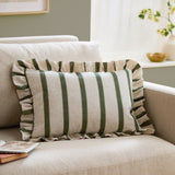 Connie Striped Linen Cushion in Moss, a rectangular cushion with moss green vertical stripes on natural oatmeal linen and a ruffled edge trim, shown on a beige sofa.