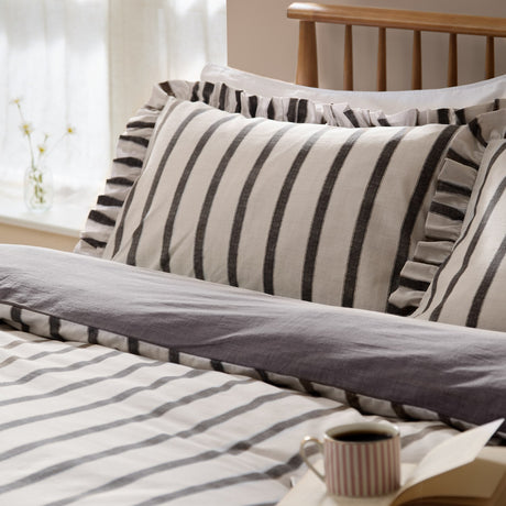 Connie Linen Plain Duvet Cover Set in Chocolate, striped cream and dark brown design with ruffle-trimmed pillowcases, shown styled on a bed in a bedroom setting.