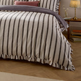 Connie Linen Plain Duvet Cover Set in Chocolate, a cream and dark brown striped cotton-blend duvet with ruffled edge trim, shown on a bed in a bedroom setting.
