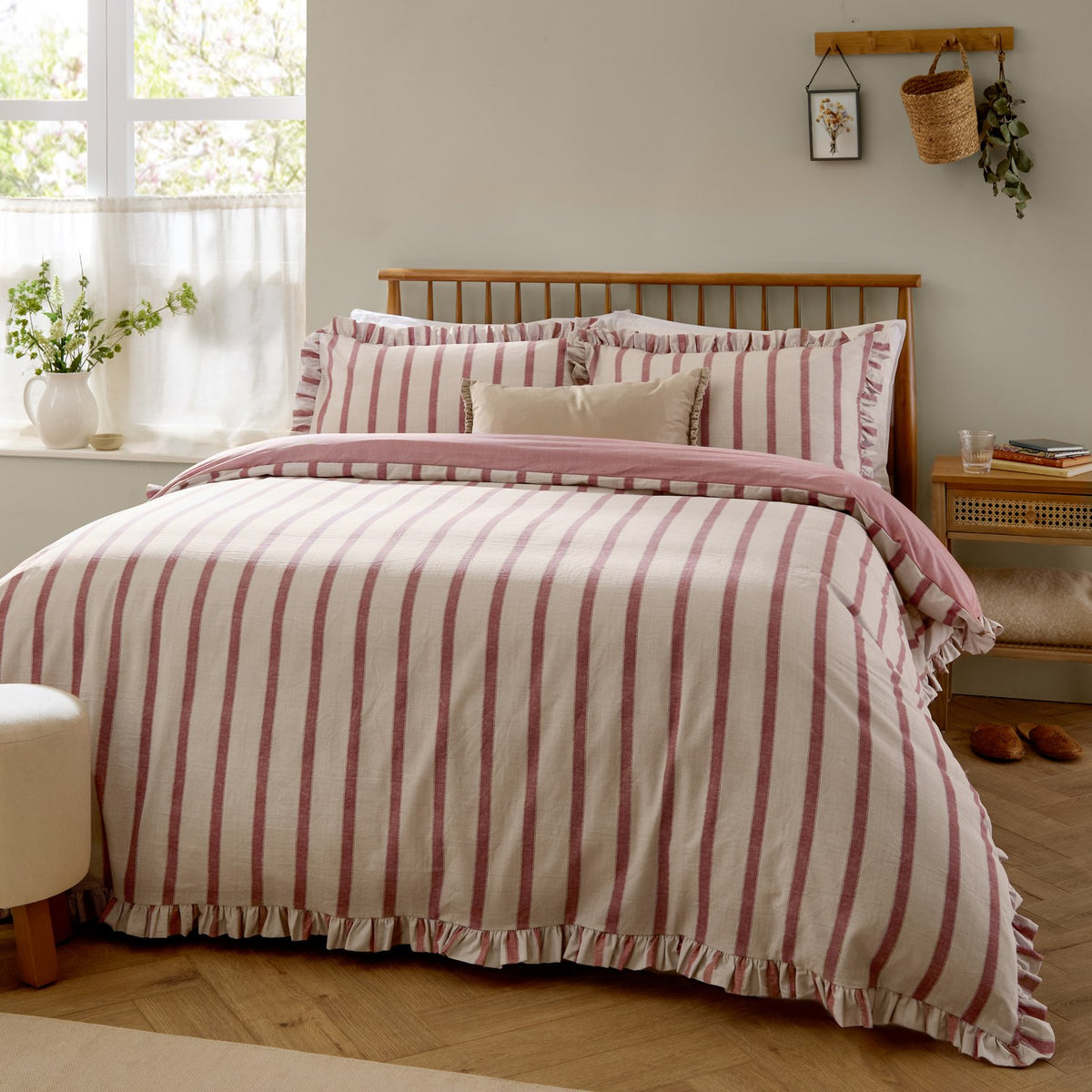 Connie Linen Duvet Cover Set in Clay Pink, reversible cream and pink striped cotton-blend bedding with ruffle trim edge, shown styled on a bed in a bedroom setting.