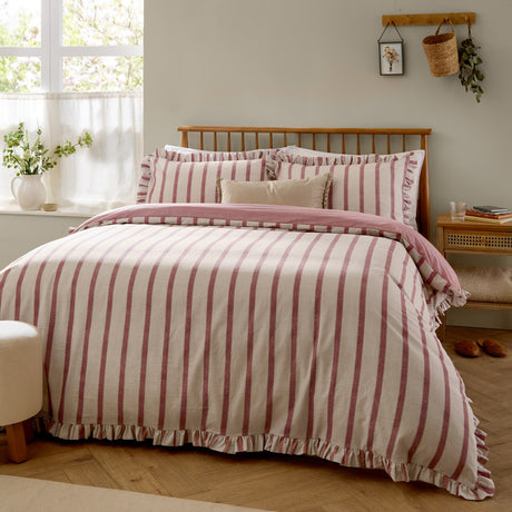 Connie Linen Duvet Cover Set in Clay Pink, reversible cream and pink striped cotton-blend bedding with ruffle trim edge, shown styled on a bed in a bedroom setting.