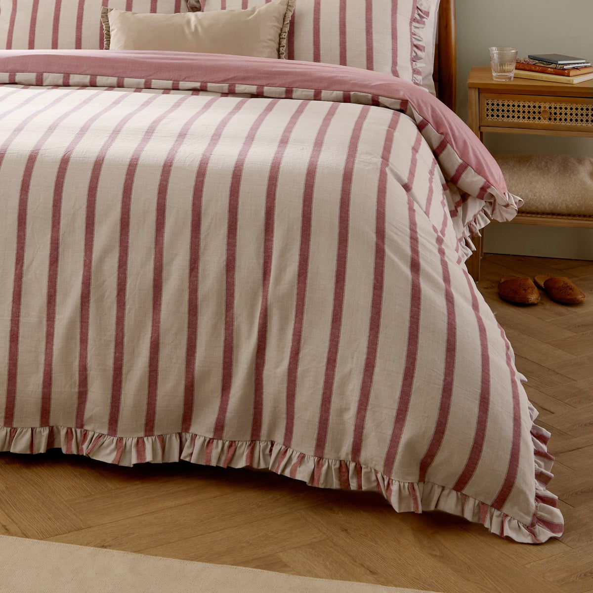Connie Linen Duvet Cover Set in Clay Pink, striped cream and pink cotton-blend design with ruffle trim, styled on a bed in a bedroom setting.