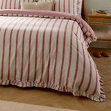 Connie Linen Duvet Cover Set in Clay Pink, striped cream and pink cotton-blend design with ruffle trim, styled on a bed in a bedroom setting.