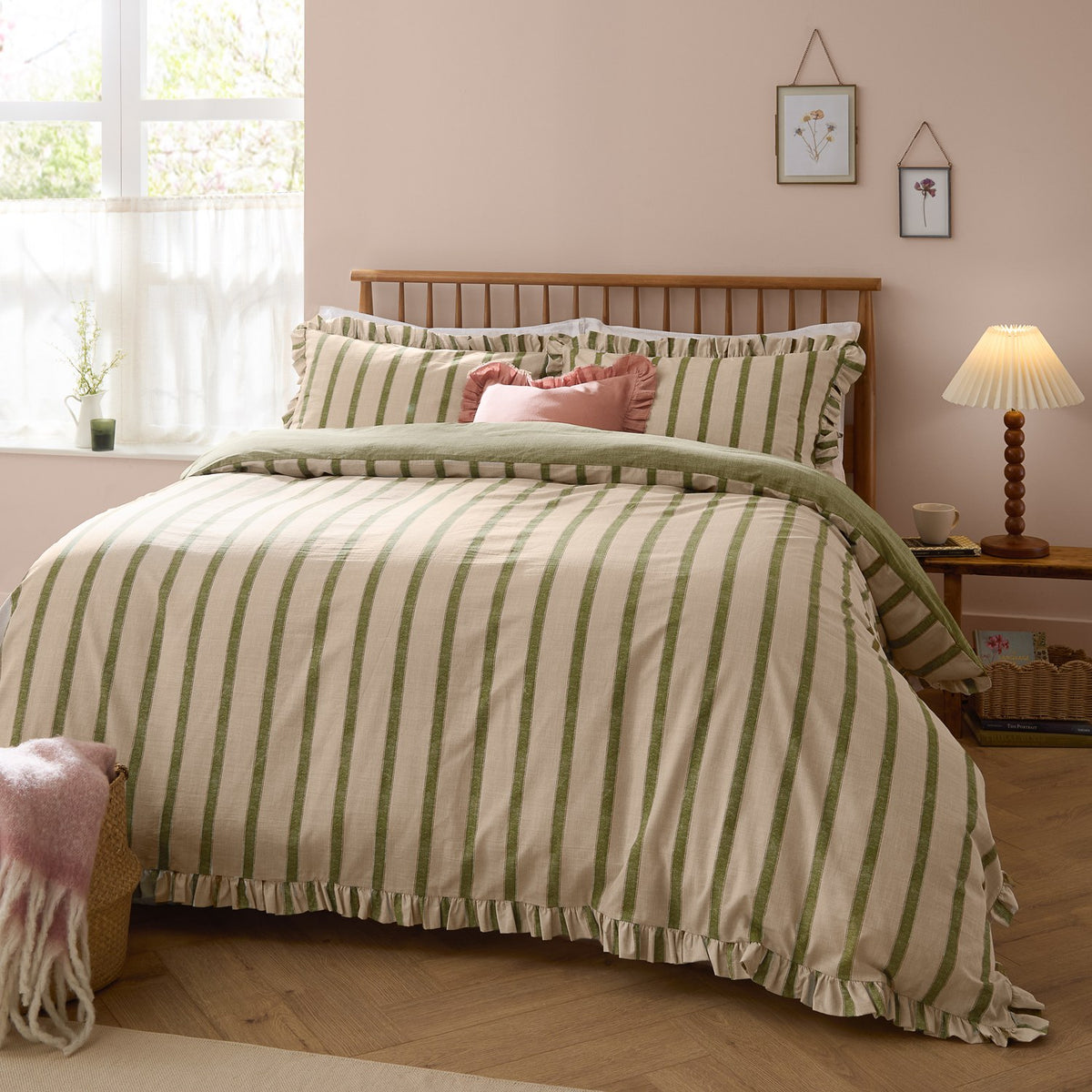 Connie Linen Plain Duvet Cover Set in Olive on a bed with ruffle-trimmed edges, striped cotton-blend cover and pillowcases in a pink-walled bedroom setting.