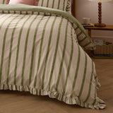 Connie Linen Plain Duvet Cover Set in Olive on a bed, showing broad olive-green stripes on natural cotton fabric with a ruffled edge trim, styled in a bedroom with a wooden side table.