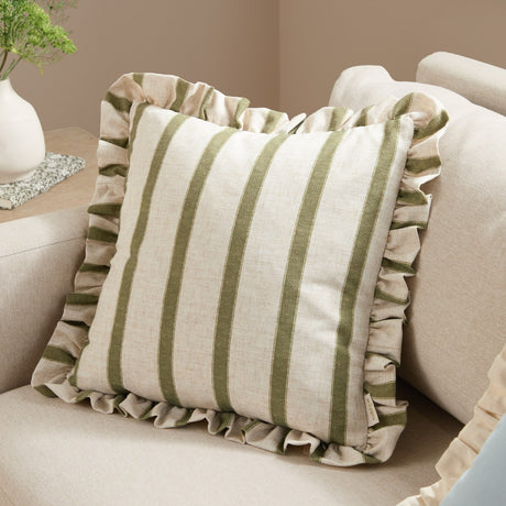 Connie Striped Linen Cushion in olive-green, square with ruffled edge trim, shown on a beige sofa in a living room setting.