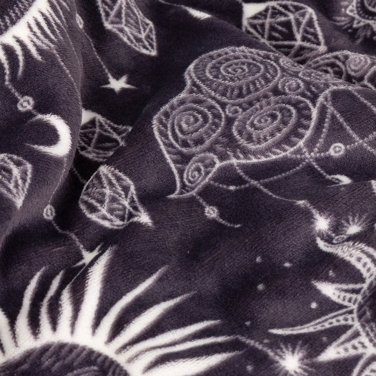 Constellation Printed Polyester Throw in charcoal, shown folded with cream celestial line-work of suns, moons, stars, eyes and faceted gems across the fabric.
