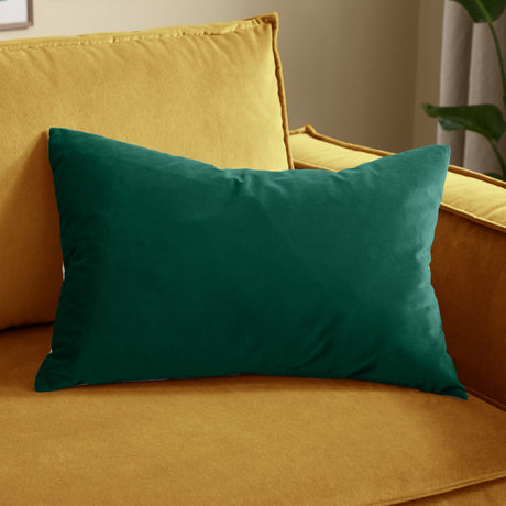 Contra Velvet Linen Cushion in teal, rectangular velvet cushion with plain finish, shown on a mustard yellow sofa.
