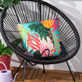 Coralina Abstract Polyester Cushion in Multi, a square cushion with a bold tropical print in turquoise, coral, green and orange, shown on a black wicker chair.