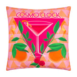 Square polyester cushion in pink with an abstract cosmopolitan cocktail print, green leaves, oranges and red berries, "Cosmo O'Clock" text, on a plain white background.