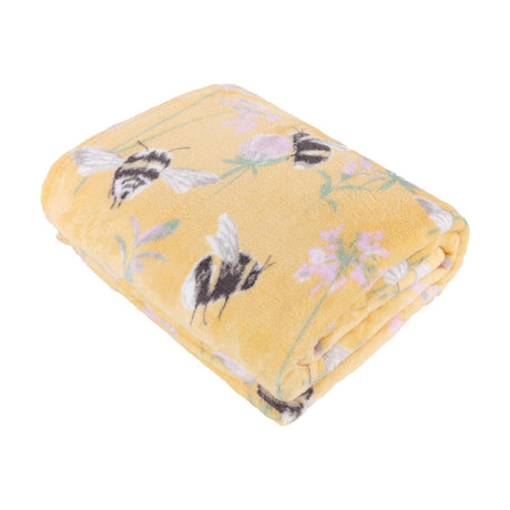 Folded honey yellow polyester throw with an all-over bumblebee print among pink clover and foliage, shown on a plain white background.