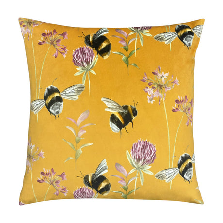 Square velvet cushion in honey yellow, 43 x 43cm, with a hand-painted bumblebee, clover and floral print, shown on a plain white background.