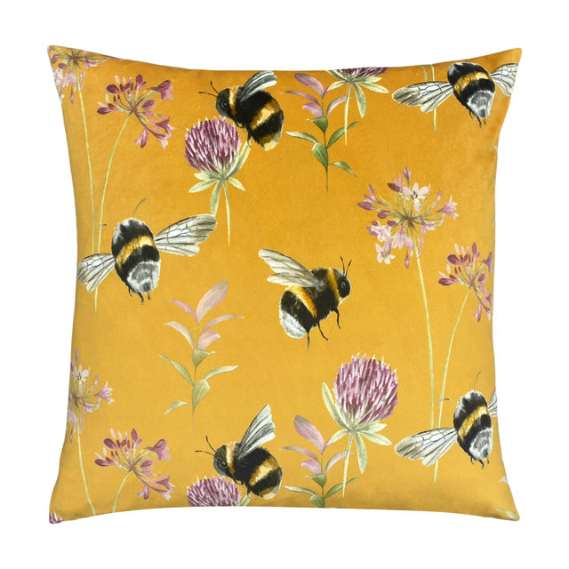 Square velvet cushion in honey yellow, 43 x 43cm, with a hand-painted bumblebee, clover and floral print, shown on a plain white background.