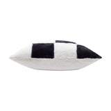 Side view of the Cozee Check faux fur cushion in black and white, showing the plump pointed edge with an oversized checkerboard pattern on one face and plain white fur on the other.