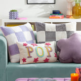Cozee Check Plain Faux Fur Cushion in lilac and white checkerboard, 50 x 50cm, shown on a teal sofa alongside patterned cushions in a living room setting.