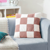 Cozee Check Plain Faux Fur Cushion in dusky pink and cream, a four-by-four checkerboard square cushion shown on a light grey sofa in a living room setting.