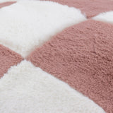 Close-up of the Cozee Check Plain Faux Fur Cushion in pink, showing a checkerboard pattern of dusky pink and cream squares in soft, long-pile fabric.