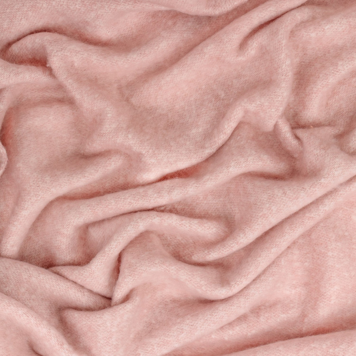 Close-up of the Cosy Plain Polyester Throw in pink, showing its soft, brushed woven texture with loosely draped folds.