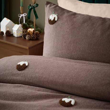 Christmas Pudding Tufted Brushed Duvet Cover Set in chocolate-brown herringbone cotton, with tufted pudding motifs on the pillowcase and duvet, styled on a bed in a bedroom.