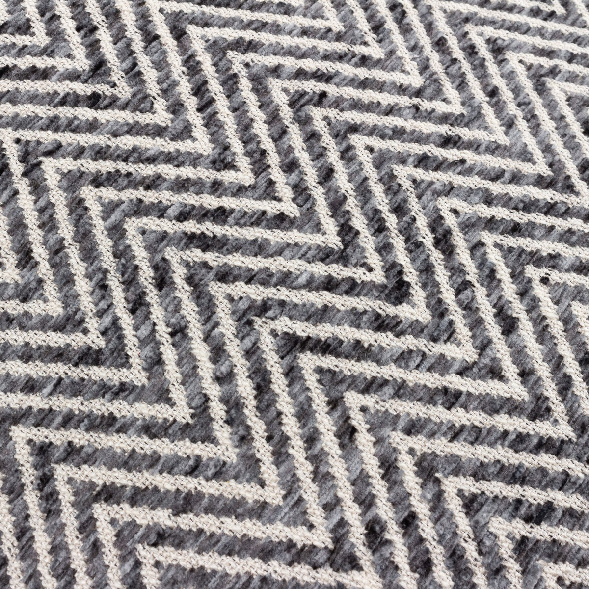 Close-up of the Croft cushion's woven front, showing a raised charcoal and cream chevron pattern in a textured twill weave.