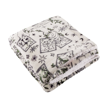 Folded Celestial Stories throw in cream polyester fleece with charcoal tarot card, star, moon and green foliage print, sherpa reverse visible, shown on a white background.