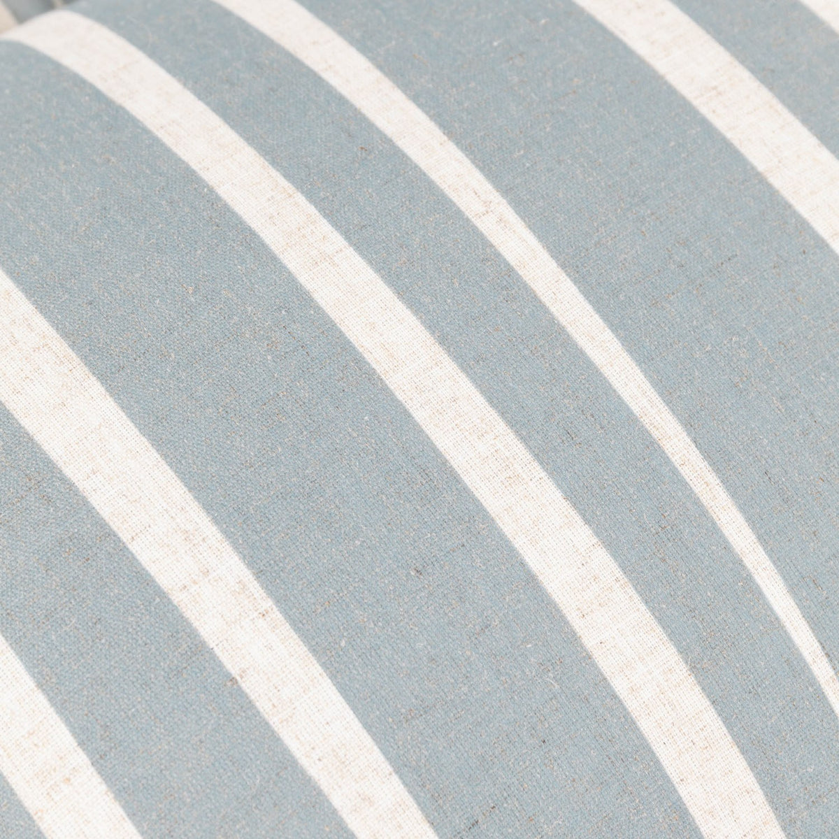 Close-up of the Carmon Stripe cushion showing soft blue and cream vertical stripes on a linen-blend woven fabric.