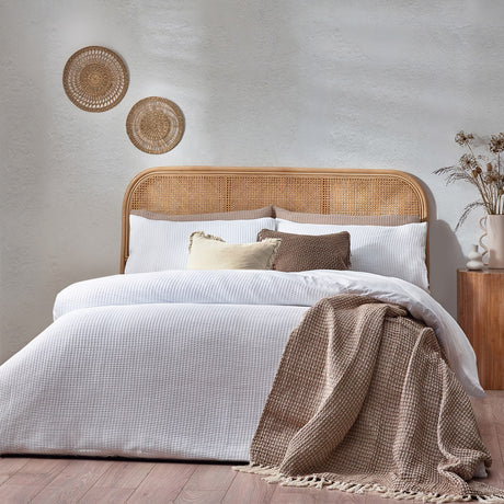 White Chunky Waffle Cotton Duvet Cover Set on a bed with rattan headboard, styled with brown throw and cushions in a bedroom setting.